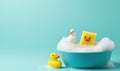 Two rubber ducks and a sponge take a bubbly bath together against a clean, bright backdrop. Royalty Free Stock Photo