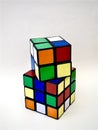 Two Rubik's cubes stacked on each other with white background