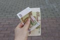 Female hand holding new russian banknotes against window. two hundred roubles. Cash paper money Royalty Free Stock Photo