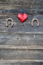 Two rusty horseshoe and heart symbol on wooden wall Royalty Free Stock Photo