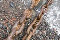 Two rusty shipping chains on the seashore Royalty Free Stock Photo