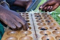 Two Rwandan Men`s Hands Shown Playing a Local Board Game Called Igisoro