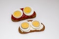 Two rye bread sandwich with two halves of boiled egg with tomato sauce on white background Royalty Free Stock Photo