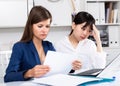 Two sad women looking documents at table in the office Royalty Free Stock Photo