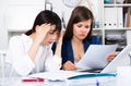 Two sad women looking documents at table in the office Royalty Free Stock Photo