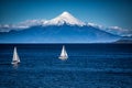 Two sailboats sail in front of snow capped Orsono Volcano in Chile Royalty Free Stock Photo