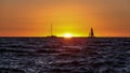 Two sailboats sailing across the ocean with scenic sunset Royalty Free Stock Photo