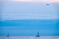 Two Sailing yachts in the blue calm sea and landing plane in the sky Royalty Free Stock Photo