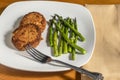 two salmon cakes with sauteed asparagus