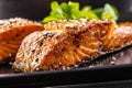 Two salmon fillets baked until crispy with sesame - Close up