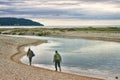 Two salmon fishermen walking along the Platte River outlet.