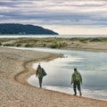 Two salmon fishermen walking along the Platte River outlet.