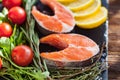 Two salmon steakes with greenery, lemon and cherry tomatoes