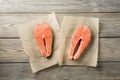 Two salmon steaks on a wooden table. Red fish steaks, shot from above