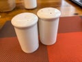 Two salt shakers sit on a red and white tablecloth Royalty Free Stock Photo