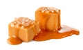 Two salty caramel candy cubes topped with caramel sauce and salt on white background Royalty Free Stock Photo