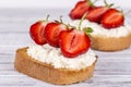 Two sandwich from red strawberry, white cottage cheese and bread on the white wooden table, close up Royalty Free Stock Photo