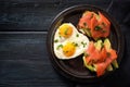 Two sandwiches with avocado and smoked salmon and two fried eggs in one heart shape, romantic valentines day meal for a couple on