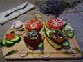 two sandwiches on a wooden Board rustic in the background blue flowers with Cutlery on the tablecloth. selective focus