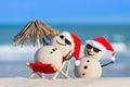 Two Sandy Christmas Snowmen are enjoying the beach Royalty Free Stock Photo