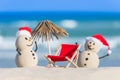 Two Sandy Christmas Snowmen are enjoying the beach Royalty Free Stock Photo