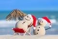 Two Sandy Christmas Snowmen are enjoying the beach Royalty Free Stock Photo
