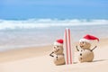 Two Sandy Christmas Snowmen are watching the waves Royalty Free Stock Photo