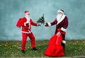 Two Santa Claus collect a big bag of gifts for Christmas. Royalty Free Stock Photo