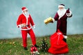 Two Santa Claus collect a big bag of gifts for Christmas. Royalty Free Stock Photo