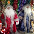 Two Santa Clauses in different clothes stand side by side