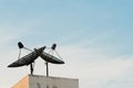 Two satellite dishes during sunset with copy space on blue sky background Royalty Free Stock Photo