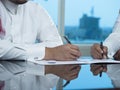 Two Saudi Businessmen Hands Signing A Ducument Royalty Free Stock Photo