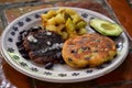 Two savory black bean and potato pancakes served on a plate with angua a la cocina, mexican food background image Royalty Free Stock Photo