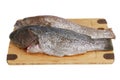 Two scaled grouper fish on bamboo cutting board