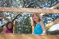 Two happy young girls sitting in a treehouse in the garden