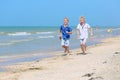 Two school boys running on the beach