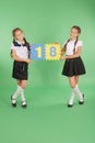 Two school girls hold color board with the number eighteen Royalty Free Stock Photo