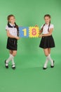 Two school girls hold color board with the number eighteen Royalty Free Stock Photo