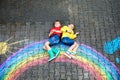 Two school kids boys having fun with with rainbow picture drawing with colorful chalks on asphalt. Siblings, twins and Royalty Free Stock Photo