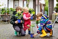 Two school kids boys and little toddler girl with tomato and cucumber seedings. Three children gardening in spring on Royalty Free Stock Photo