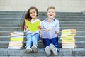 Two schoolchildren read books and laugh. The concept is back to school, education, reading, friendship and family Royalty Free Stock Photo