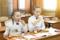 Two schoolgirls eat on the bench in the classroom Royalty Free Stock Photo