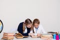 Two schoolgirls girls in class at her desk with books notebooks Royalty Free Stock Photo