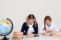 Two schoolgirls girls in class at her desk with books notebooks Royalty Free Stock Photo