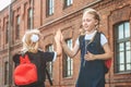 Two Schoolgirls give each other five. First day of study. Concept on the topic Back to School.