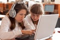 Two schoolgirls performs task using notebook Royalty Free Stock Photo