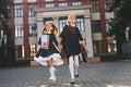 Two schoolgirls is running outside together near school building Royalty Free Stock Photo