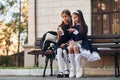 Two schoolgirls is sitting outside together near school building Royalty Free Stock Photo