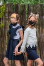 Two schoolgirls wearing masks and going back to school during covid-19 pandemic.Two schoolgirls wearing protective masks Royalty Free Stock Photo