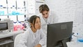 Two scientists, a man and a woman, are analyzing data on a computer in a modern laboratory setting Royalty Free Stock Photo
